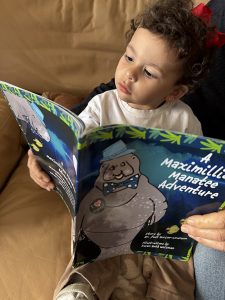 Toddler H reading Maximillian Manatee copy